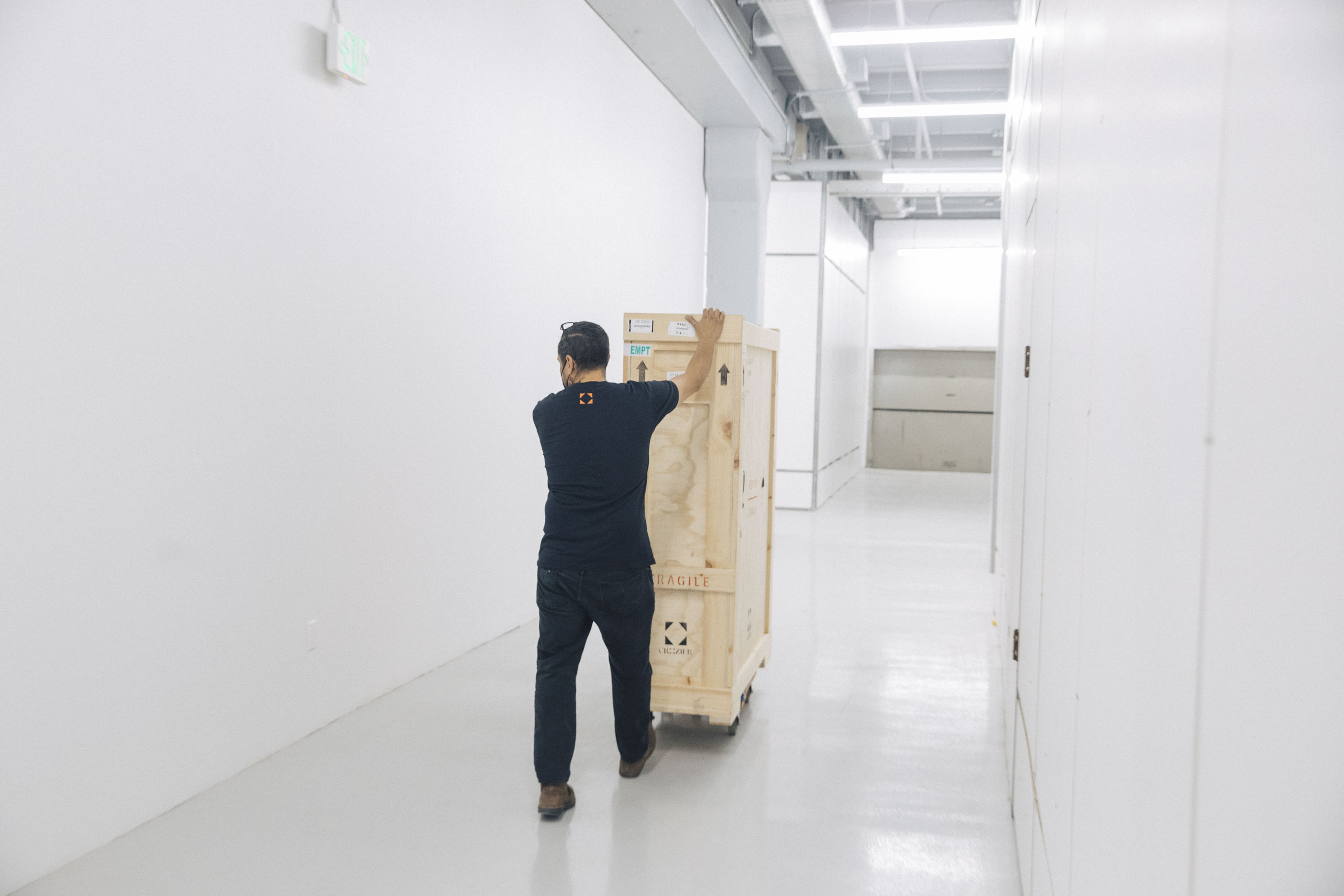 An art handler moving a large transit crate