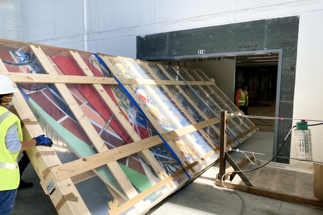 Crozier team members handle 'Just What Is Your Position' by Renée Petropoulos at the LAX Delta Terminal installation 